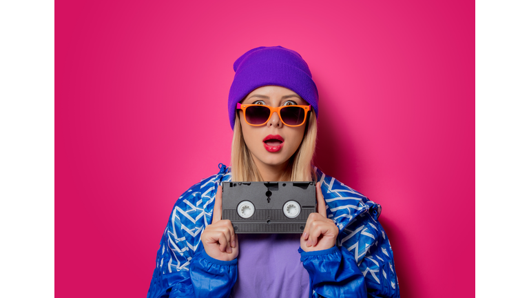 girl in 90s sports jacket and VHS cassette