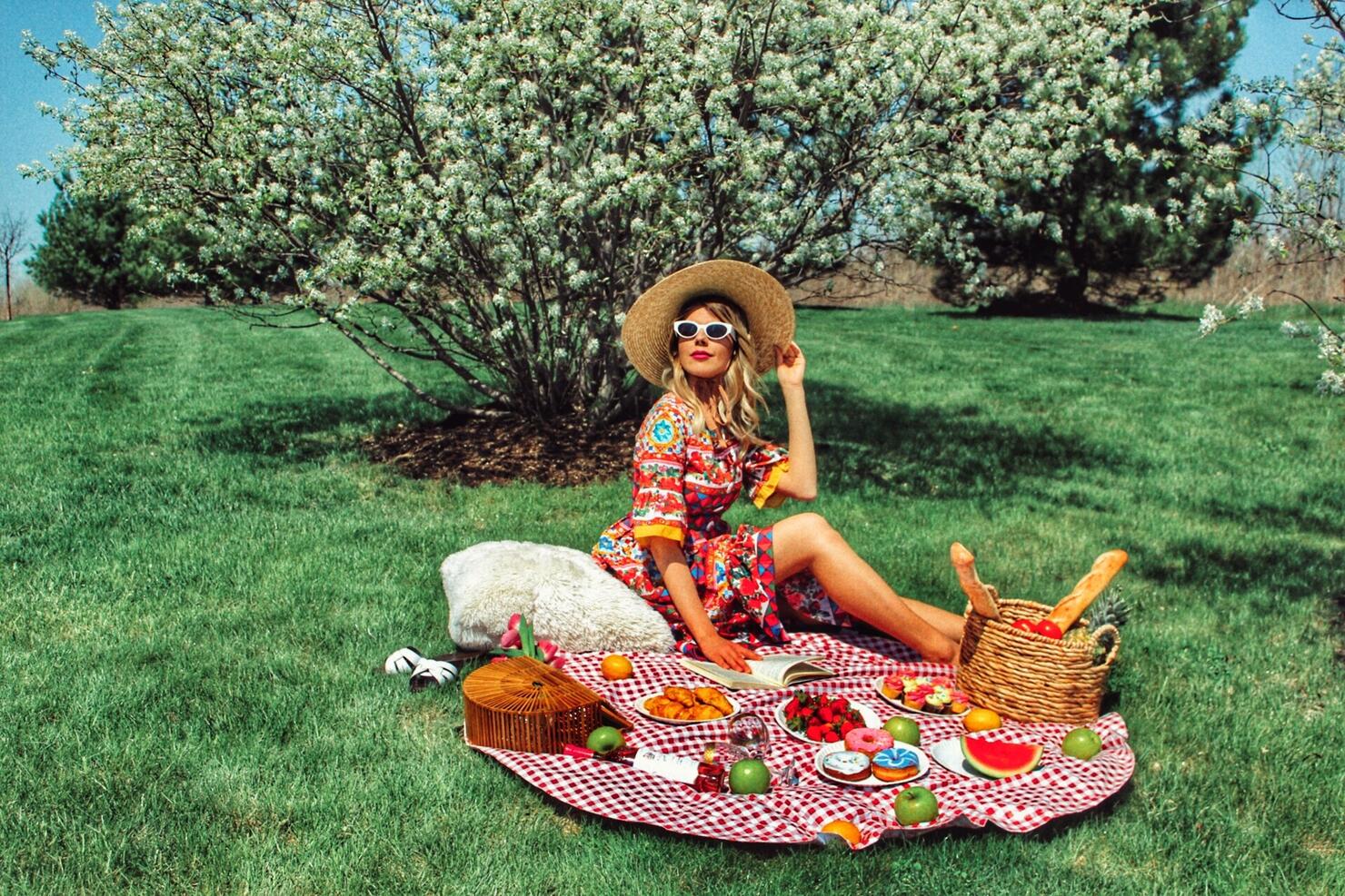 Smiling Woman Enjoying Picnic On Field At Park