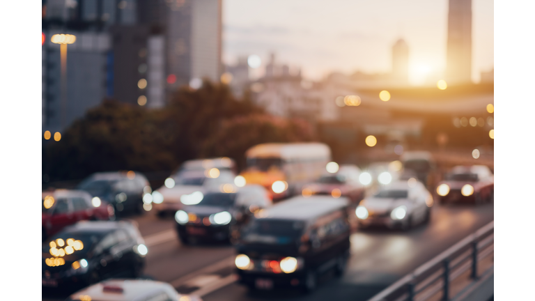 Blurry image of rush hour traffic on busy highway at sunset