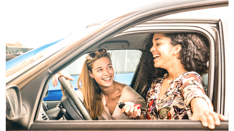 Young female best friends having fun at car roadtrip moment - Transportation concept and urban ordinary life with women girlfriends at happy travel vacation on the road - Bright azure filter