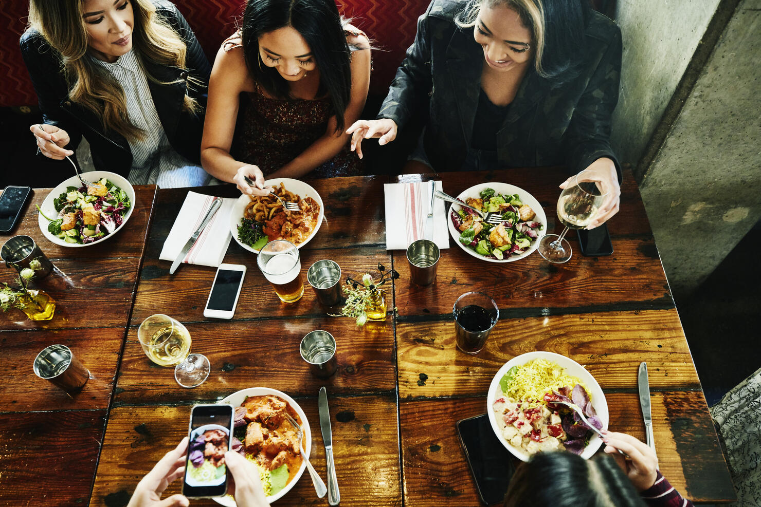Overhead view of smiling female friends sharing lunch in restaurant
