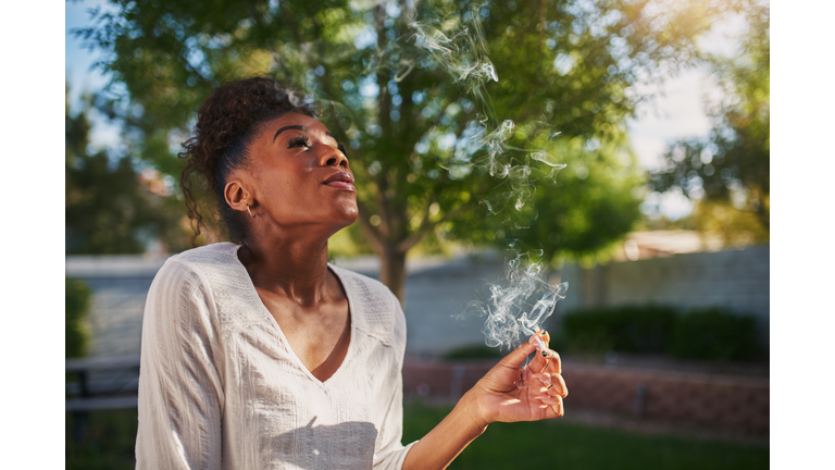 happy african american woman smoking marijuana joint