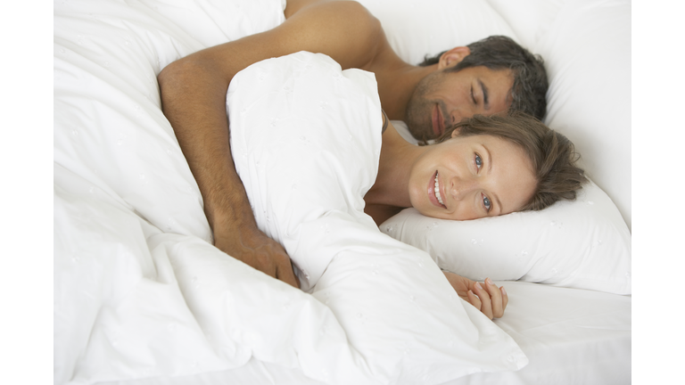 Woman and man lying down in bed