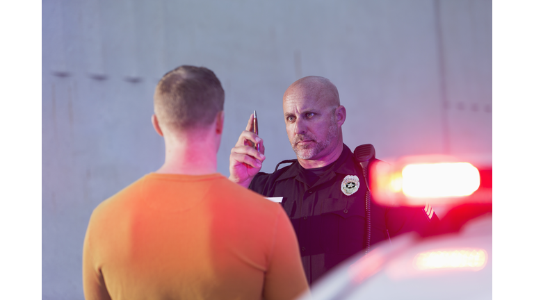 Policeman performing sobriety test on driver