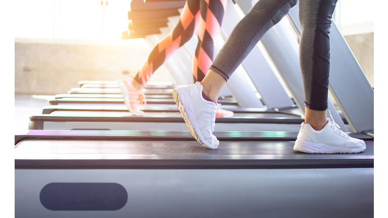 Exercise treadmill cardio running workout at fitness gym of woman taking weight loss with machine aerobic for slim and firm healthy in the morning.Show of running shoes, rubber floor, softness,