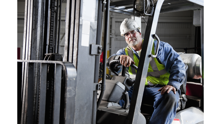 Worker driving forklift