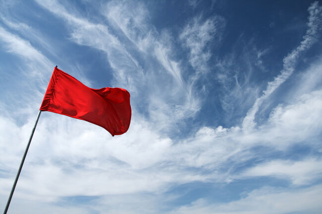 Low Angle View Of Red Flag Against Sky
