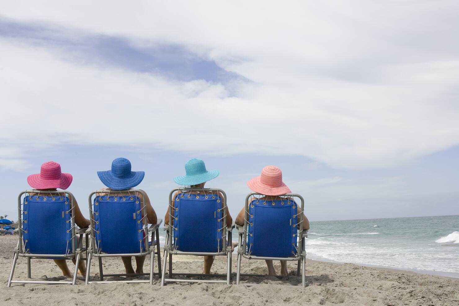 Rear view of four women in beach chairs