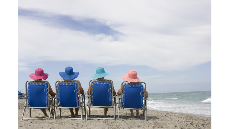 Rear view of four women in beach chairs