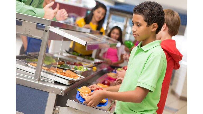 Middle school students getting lunch items in cafeteria line