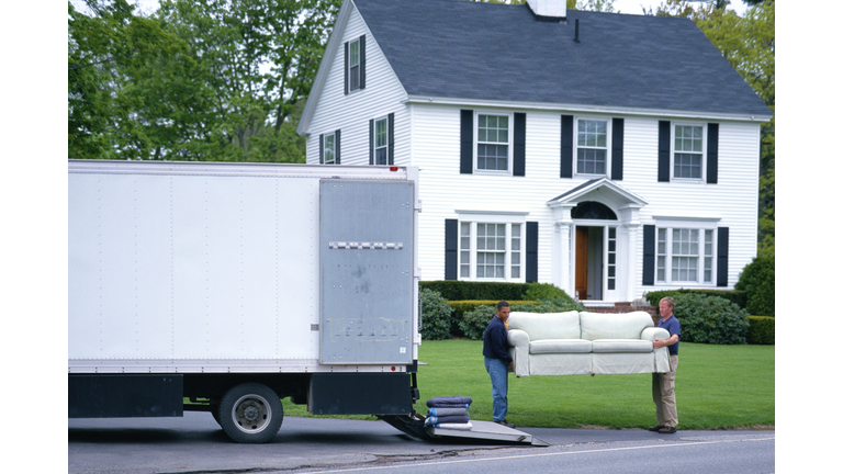 MOVING MEN UNLOAD FURNITURE FROM TRUCK