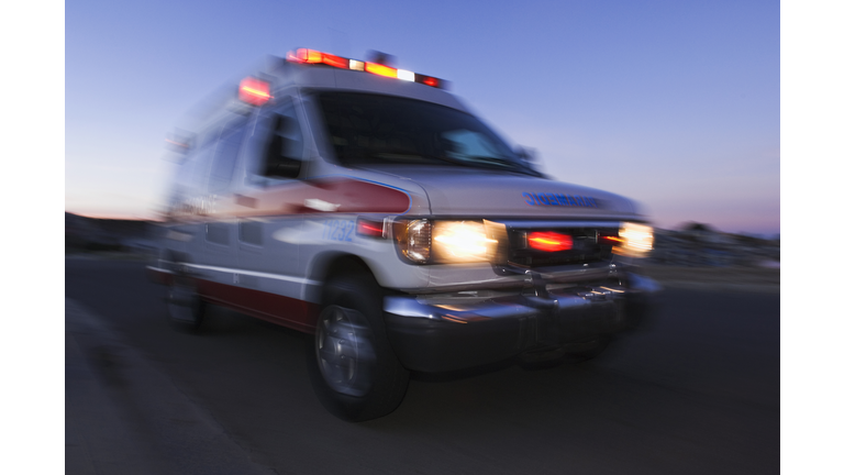 Blurred view of ambulance driving at dusk