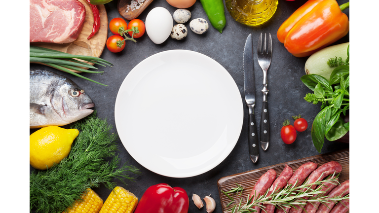 Empty plate surrounded by cooking ingredients