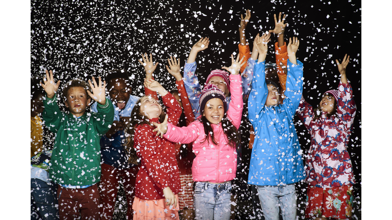 Group of children dressed in winter coats having fun in the snow