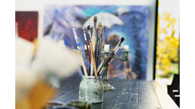 Paintbrushes in container on table at art studio