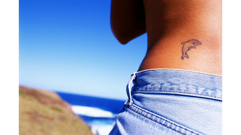 Dolphin tattoo on back of woman