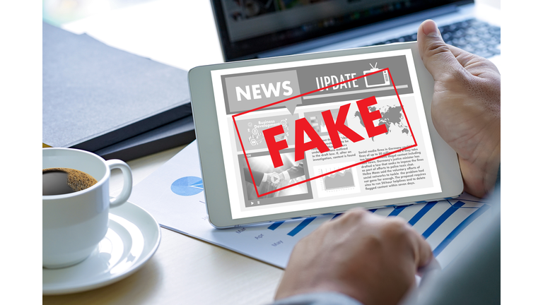 Cropped Hand Holding Fake News In Digital Tablet