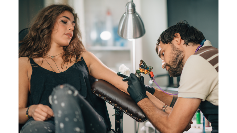 Artist Making Tattoo On Woman Hand At Studio