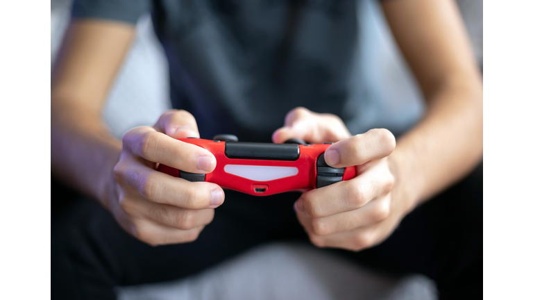 young man playing video game with gamepad front view