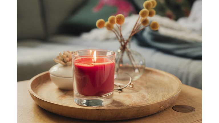 Scented candle burning on sofa table