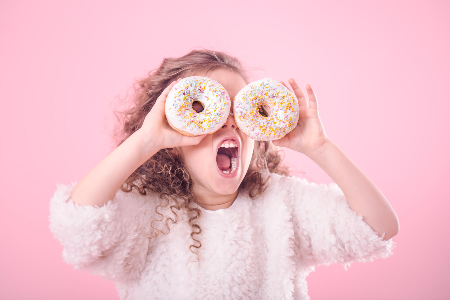 Portrait of a girl with an open mouth and donuts