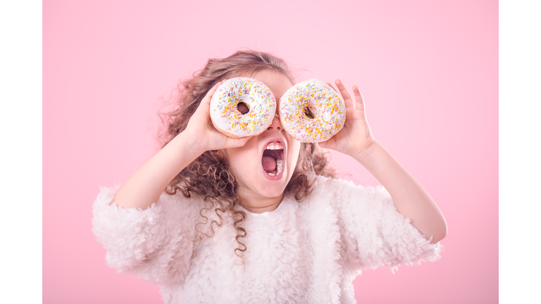 Portrait of a girl with an open mouth and donuts