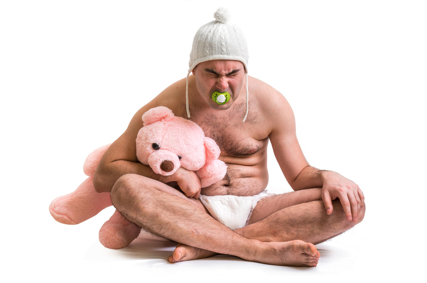 Man as baby. Child in diaper with pink teddy bear.