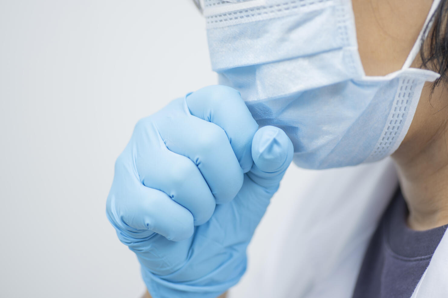 Woman doctor wearing white coat and mask feeling unwell and coughing