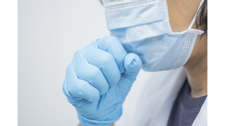 Woman doctor wearing white coat and mask feeling unwell and coughing