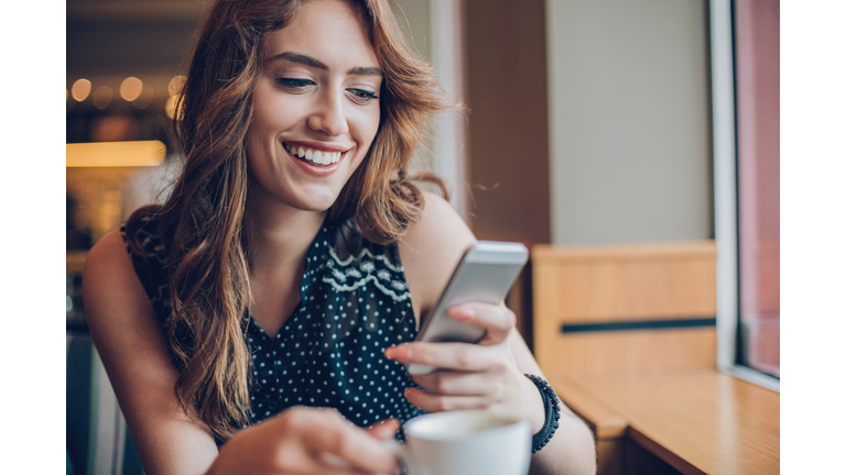 Beautiful girl texting in cafe