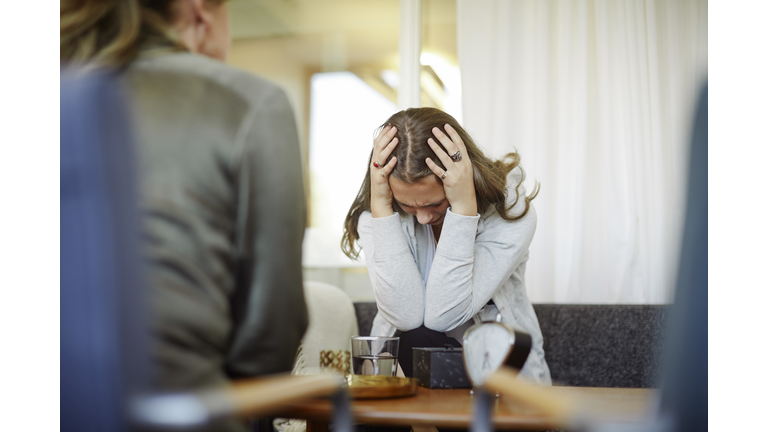 Displeased female patient discussing with therapist during session