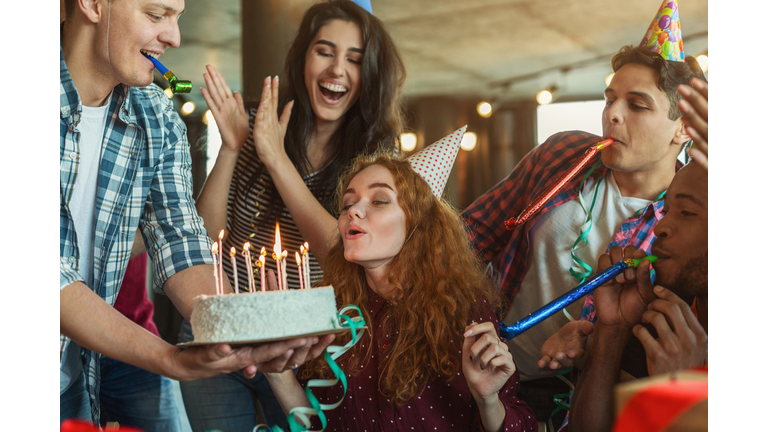 Friends presenting birthday cake to girl