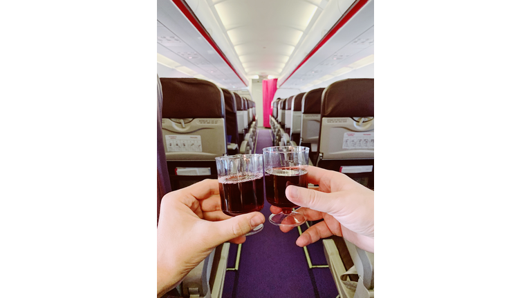 Drinking red wine from plastic cups on a plane