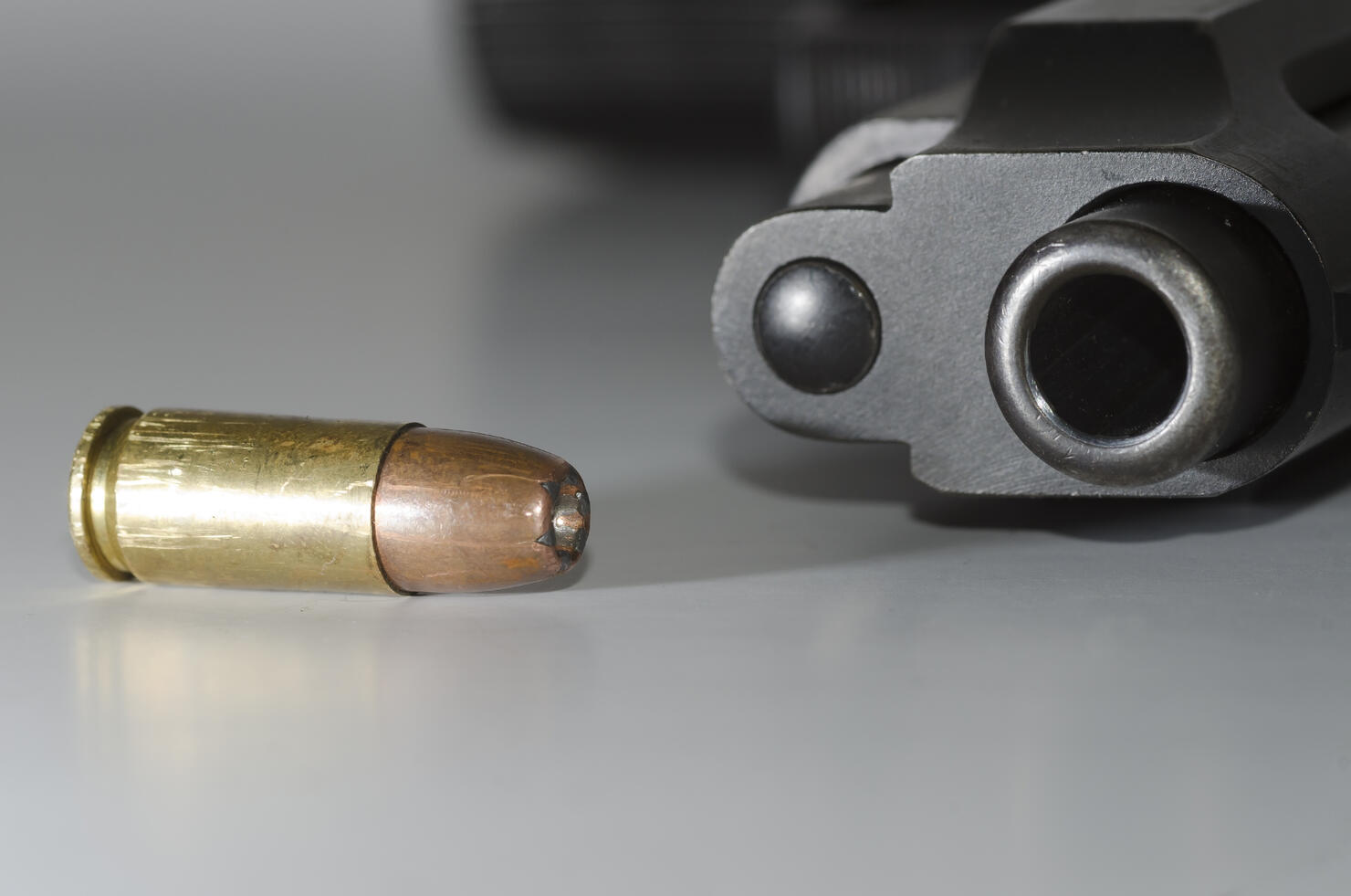 Close-Up Of Gun And Bullet On Table
