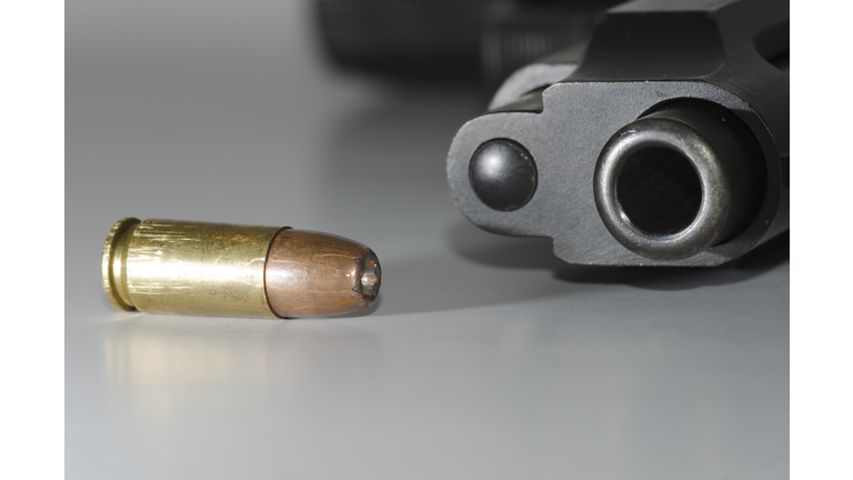 Close-Up Of Gun And Bullet On Table