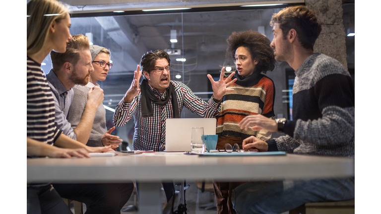 Furious boss shouting at his team on a meeting in the office.