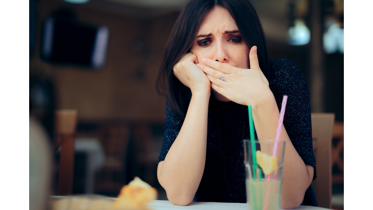 Nauseated Woman Feeling Sick at the Restaurant