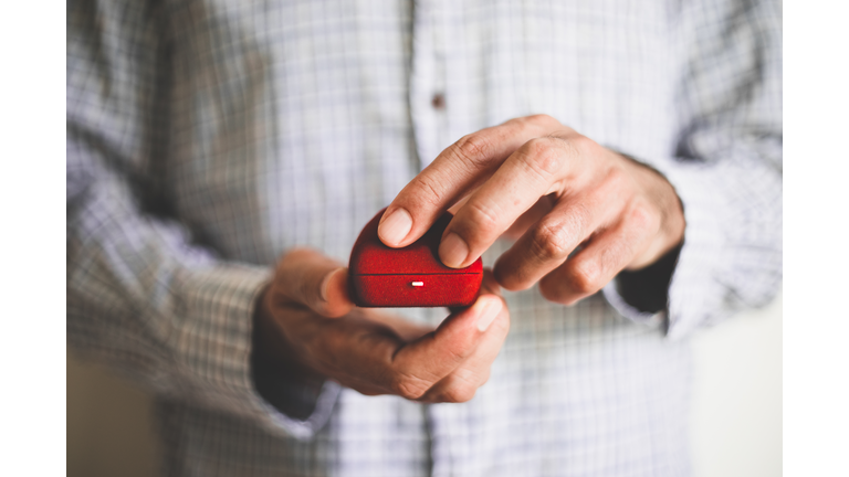 A man holding a red ring box