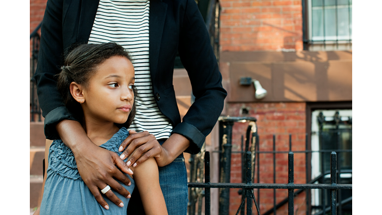 Girl standing with mother, looking away