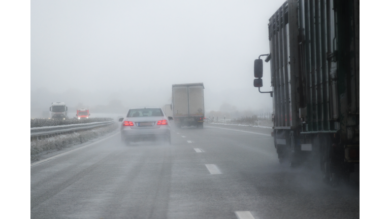 cars, trucks and rescue vehicle driving in dangerous winter weather
