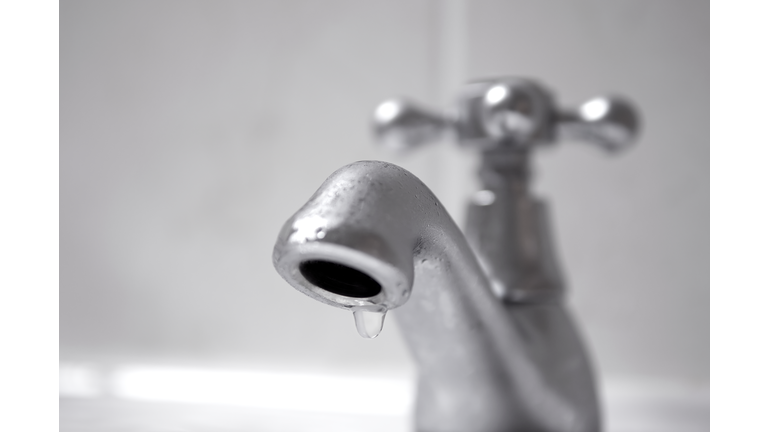 Dripping silver tap water close up