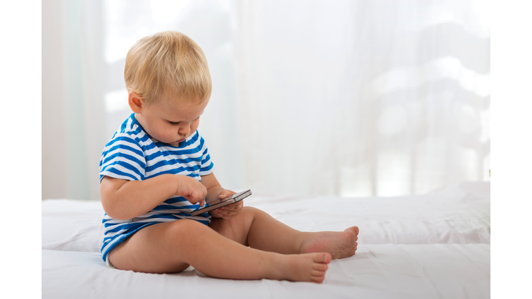 Casual baby watching a mobile phone