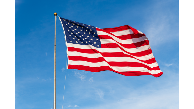 Vibrant colored American Flag waving in the wind, lit by natural sunlight