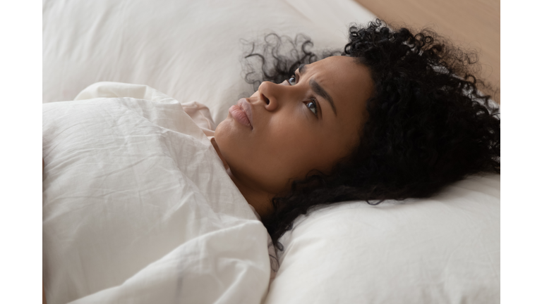 Woman lying in bed cannot fall asleep suffers from insomnia