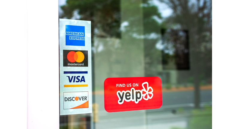 MasterCard, VISA, American Express, Discover payment options on a restaurant door
