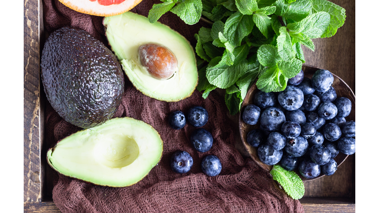 Purple smoothie with blueberries, mint, avocado and grapefruit in wooden tray. Healthy food. Summer breakfast or lunch.