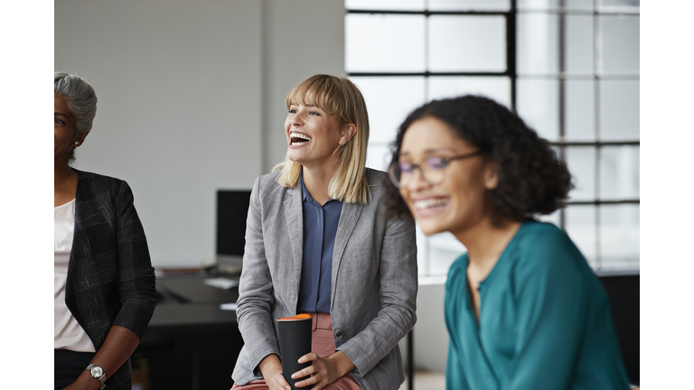 Excited businesswoman looking away in office