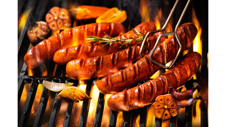 Sausages on the barbecue grill with flames