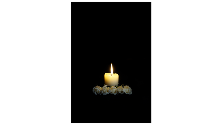 Sympathy card. Frame with white roses and burning candles in darkness. candles burning in the black background. Empty place for text. Appreciation, feelings compliment, mourning frame. Condolences card, Prayers and Deepest Sympathy concept Funeral symbol.