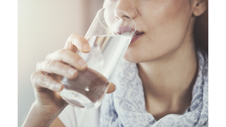 Young woman drinking pure glass of water